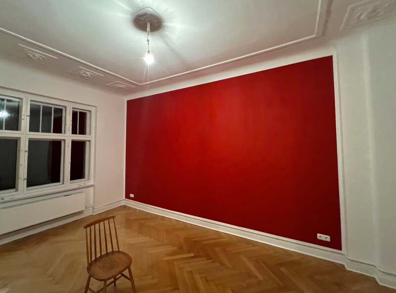 Akzentwand in kräftigem Rot – Kontrastreiche Wandgestaltung kombiniert mit klassischem Parkettboden